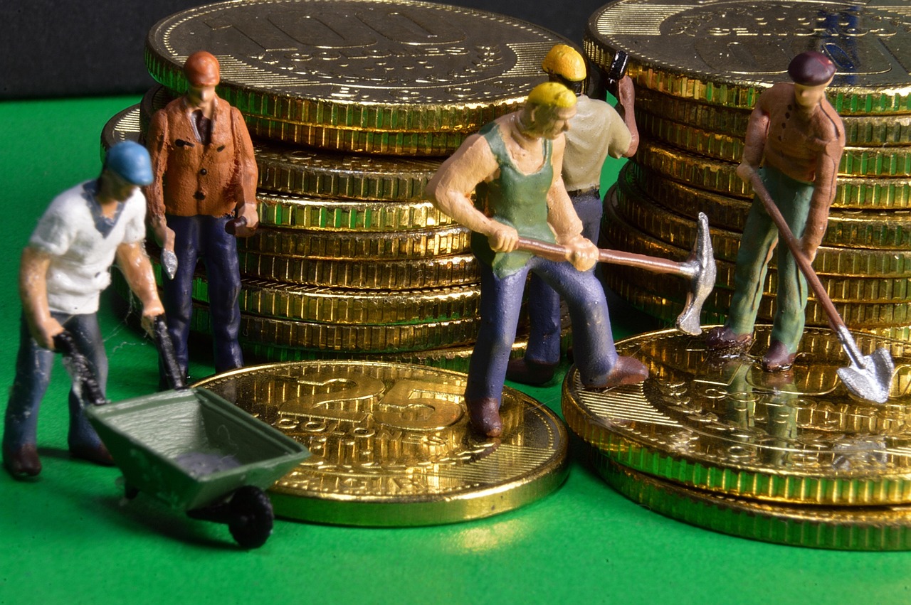 Miniature workers mining gold coins symbolizing the cost of prepayment penalties and hidden loan fees